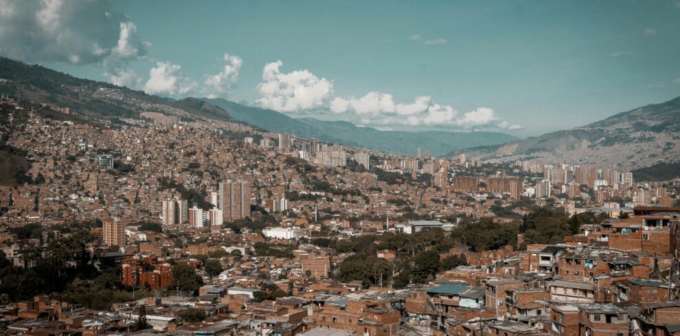 Viva medellÃn A panoramic aerial view of MedellÃn, showcasing its dense urban landscape against a backdrop of mountains.